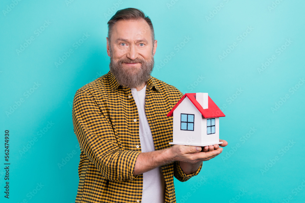 Photo of successful man wear stylish clothes hand hold house dream buy new apartment flat isolated on cyan color background Photo of successful man wear stylish clothes hand hold house dream buy new apartment flat isolated on cyan color background