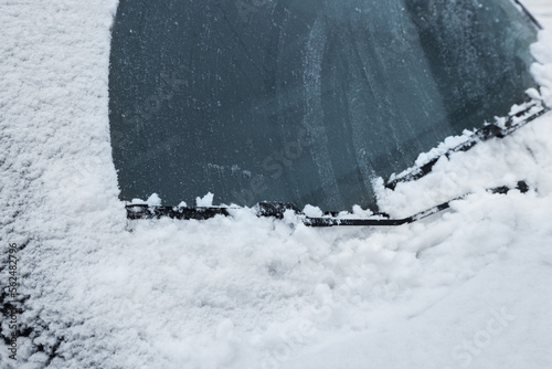 Car windshield with wiper blades cleaned from snow outdoors on winter day © New Africa