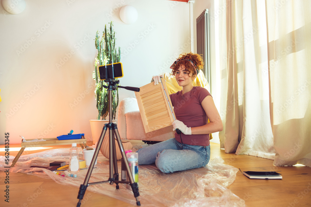 Cute ginger girl conducting an online tutorial on wood painting Cute ginger girl conducting an online tutorial on wood painting