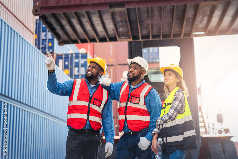 Portrait of Engineer or foreman team pointing up the future with cargo container background at sunset. Logistics global import or export shipping industrial concept. Portrait of Engineer or foreman team pointing up the future with cargo container background at sunset. Logistics global import or export shipping industrial concept.