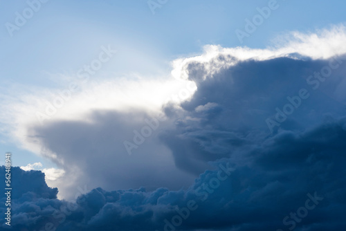 Looming dark blue clouds. Approaching thunderstorm. the sun shines through blue clouds. sky landscape