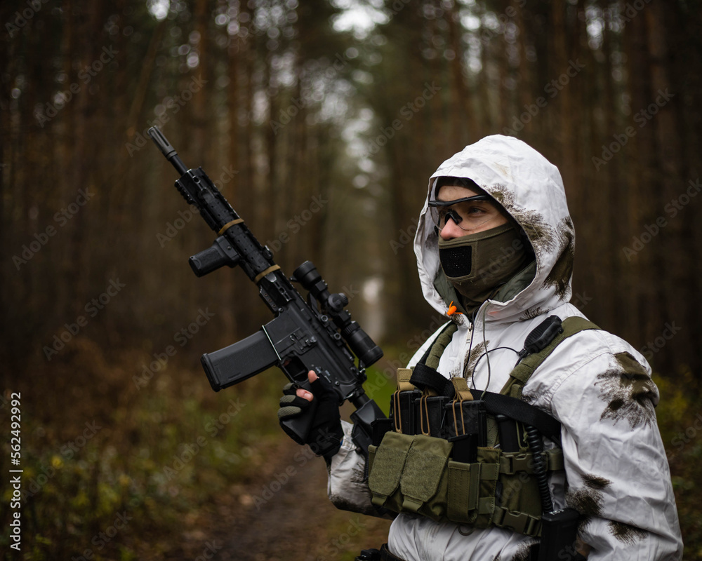 Man in a winter camo suit looking. Man in a winter camo suit looking.