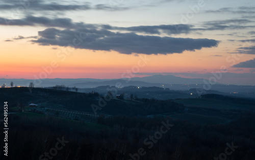 Hilly village against mountain silhouette at twilight, peaceful rural landscape in winter season on slopes of Vucijak mountain