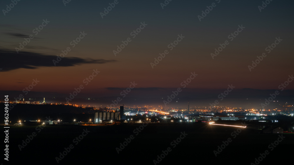 Illuminated city at late twilight, car light trails