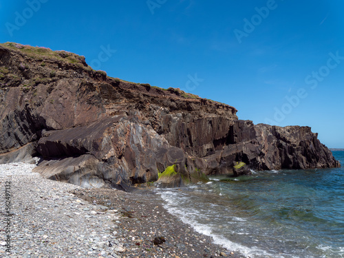 A rocky beach on the Irish coast of the Atlantic Ocean on a sunny day. Picturesque rocky coast. Seascape, rock formation on sea shore.