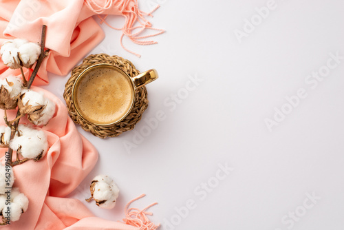 Hello spring concept. Top view photo of cup of frothy coffee on rattan serving mat pink scarf and cotton branch on isolated white background with copyspace