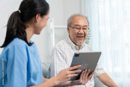 Asian nurse showing health checkup report to grandfather and giving advice. medical assisted living visit senior patient at home. Home nursing and healthcare caregiver concept