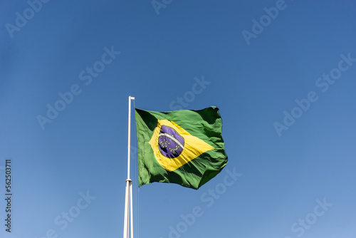 Flag of Brazil fluttering in the wind. In the center of the flag with the words "order and progress" in Portuguese.