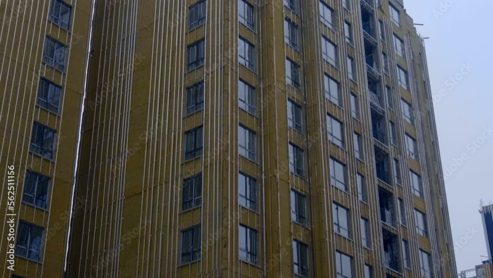 The high-rise buildings is covered with insulation sheets and is ready for the final finishing of the facade with decorative cladding panels The high-rise buildings is covered with insulation sheets and is ready for the final finishing of the facade with decorative cladding panels