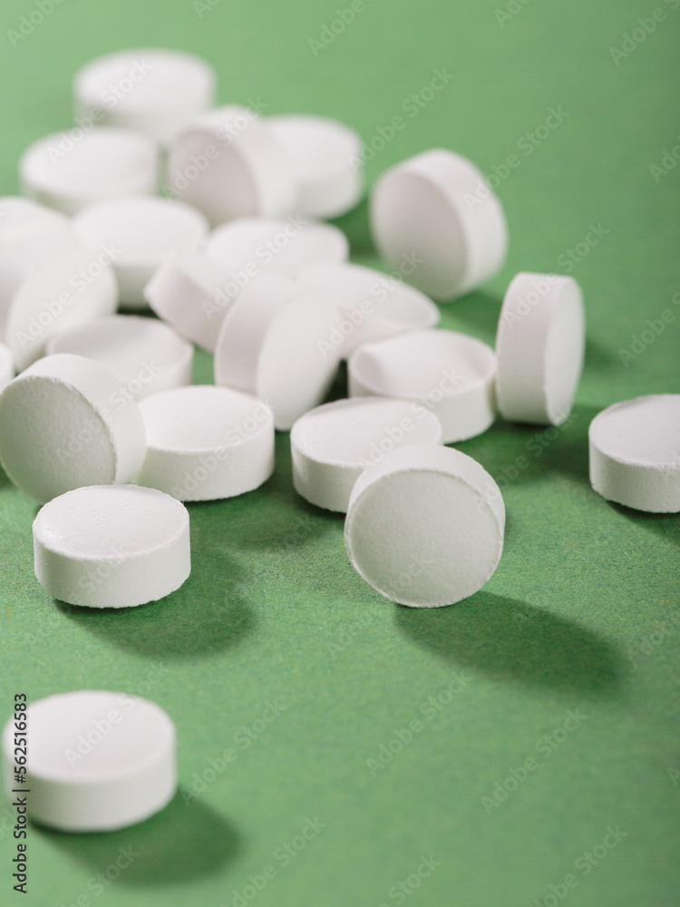 Herbal and Vitamin white pills healthy food freely laid on green background for healthy eating in daily life Herbal and Vitamin white pills healthy food freely laid on green background for healthy eating in daily life