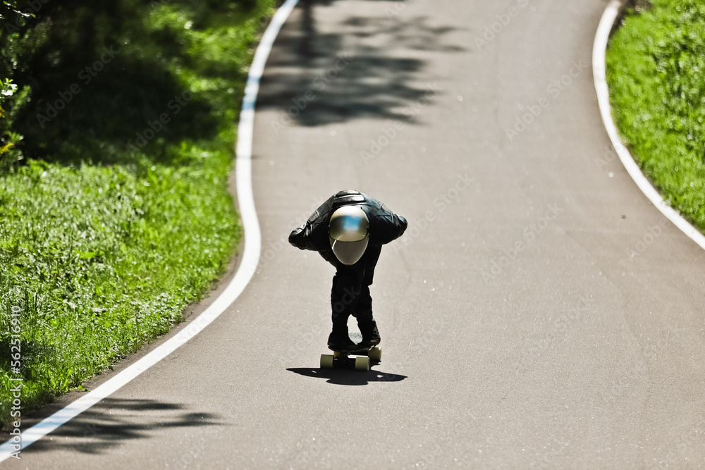 Fototapeta premium Cinematic downhill longboard session. Young man skateboarding and making tricks. Concept about extreme sports and people