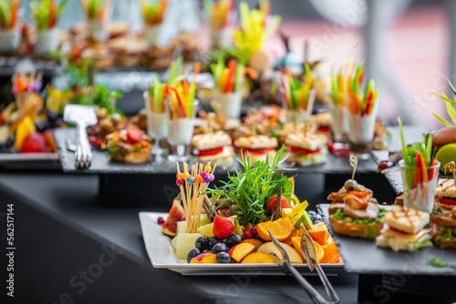 Beautifully decorated catering banquet white table with different food snacks and appetizers