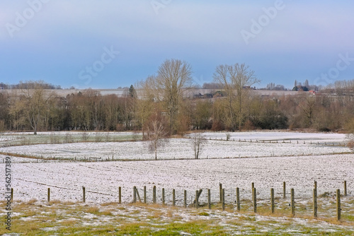 winter farm landscape covered in snow under a cear blue sky on the hills of Munkzwalm, Flanders, Belgium