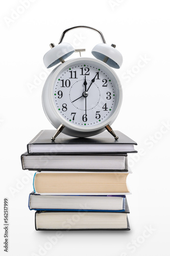 Alarm clock on a stack of books or textbooks on a white background.