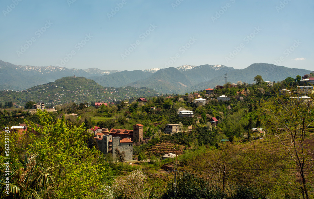 Idyllic view on hills next to Batumi with small houses ( with gardens and orchards) and Snowcapped hills in end of April