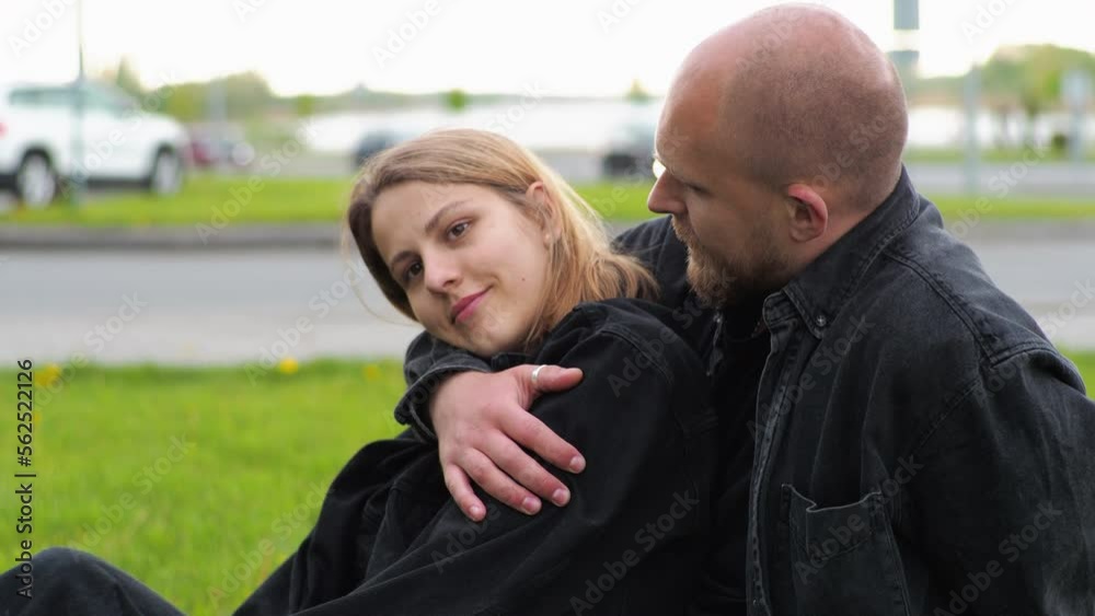 Date. Young man and woman on the lawn in the city. Fooling around, hugging, having fun, smiling.