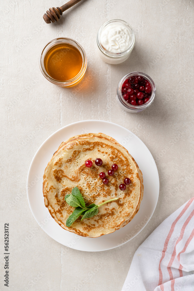Stack of homemade pancakes served with honey and berries, top view Stack of homemade pancakes served with honey and berries, top view
