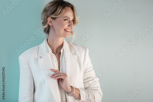 beautiful young woman, after 30, elegant dressed. Light interior. The image of a business woman with jewelry from gems and gold