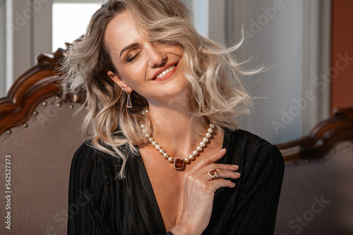 Romantic portrait of a girl dressed in an elegant dress and expensive jewelry