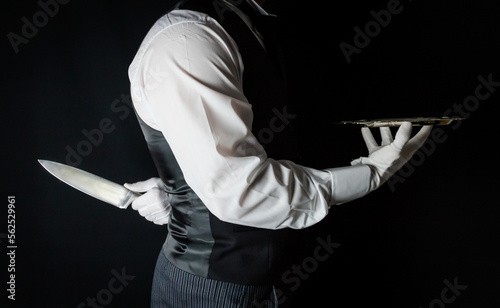 Butler or Waiter With Serving Tray and Holding Sharp Knife Behind Back. Concept of Butler Did It. Classic Murder Mystery.