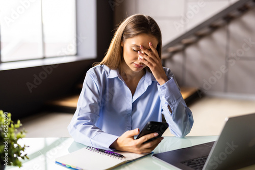 Fotografie Displeased frustrated young mixed race woman irritated by spam message, looking at smartphone screen