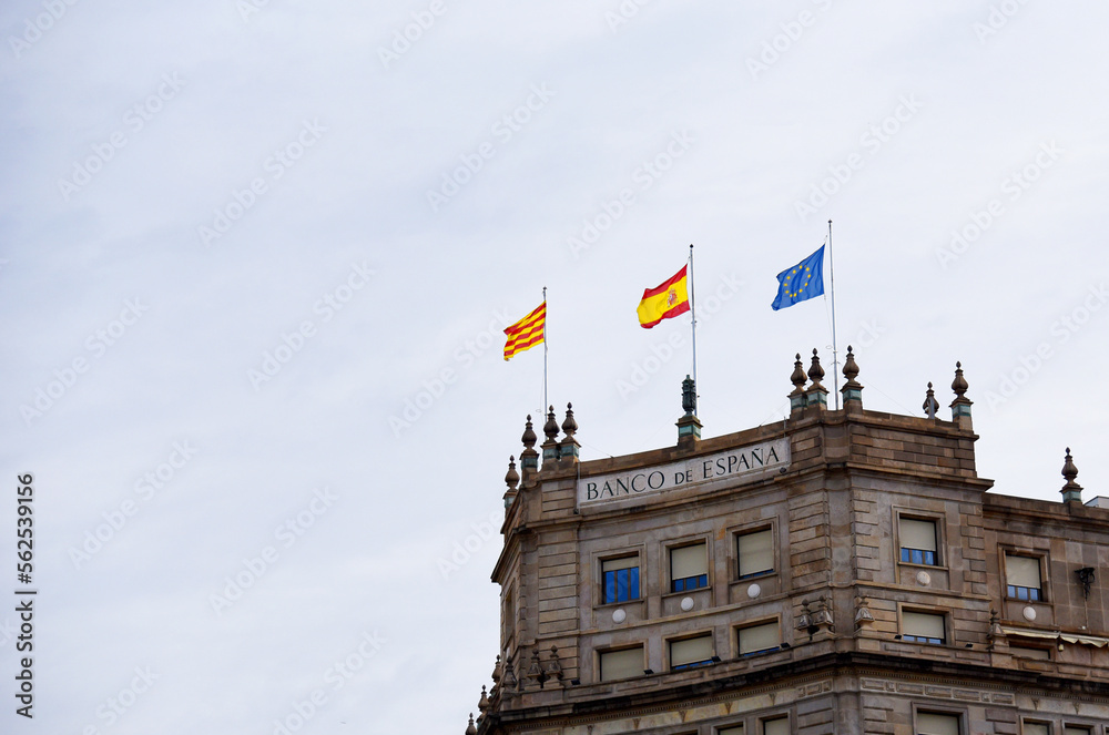 European flag and Spanish flag on the building. Barcelona and catalonia flag with european flag on historic building against cloudy sky.