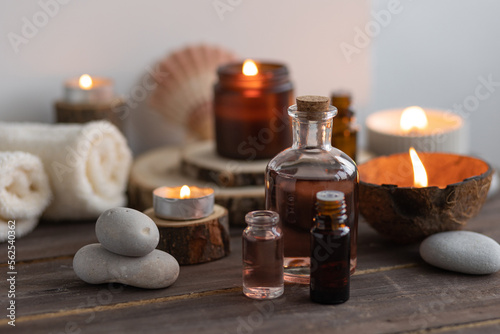 Concept of natural essential organic oils  Bali spa  beauty treatment  relax time. Atmosphere of relaxation  pleasure. Candles  towels  dark wooden background. Alternative oriental medicine