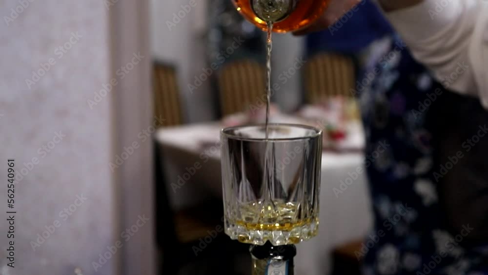pouring whiskey.virtuoso Pouring an alcoholic drink from a bottle into