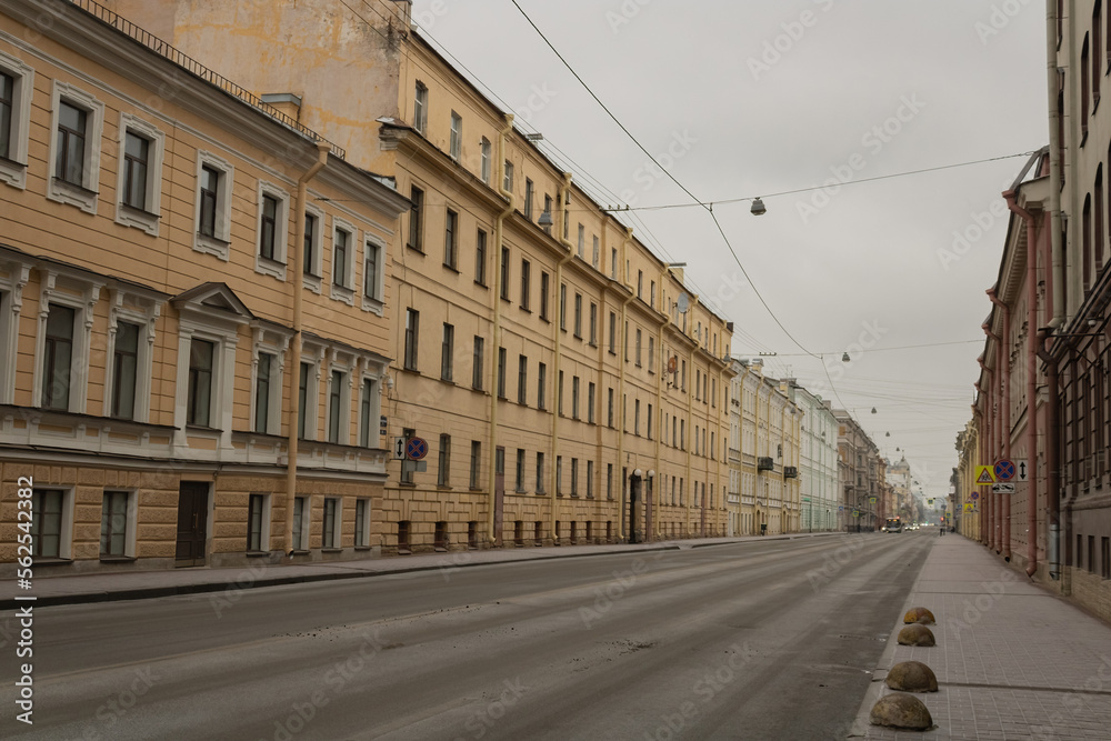 Buildings on an empty street of St. Petersburg. Automobile and pedestrian roads. Power lines. Blur. Late fall.