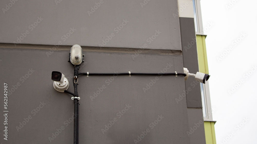Image showcasing Surveillance cameras on the wall of a high-rise apartment building ...