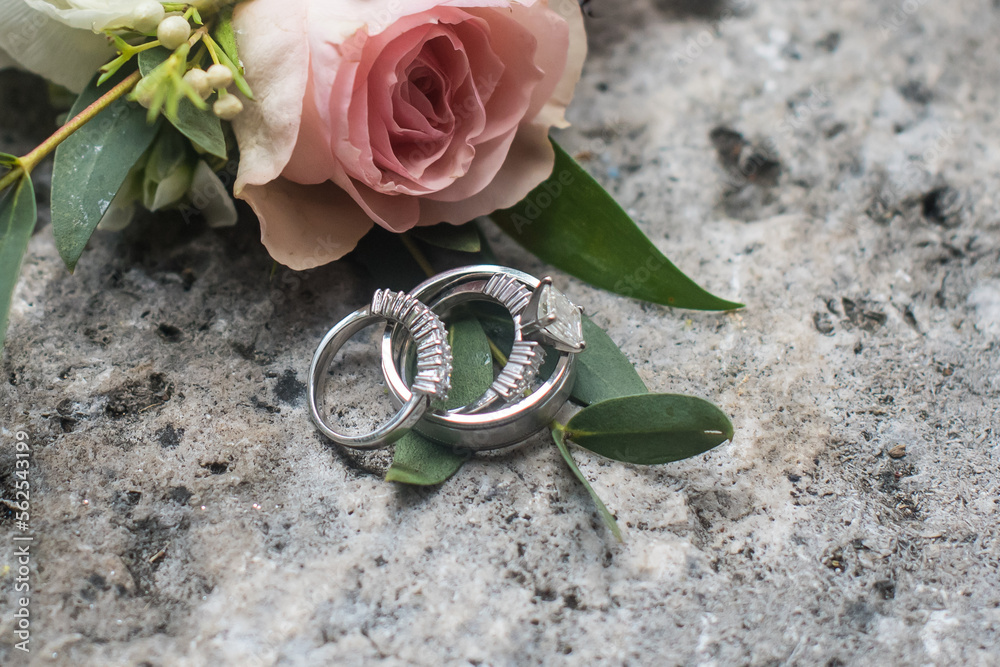 Wedding band placed on coral rock and flowers