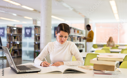 Successful woman studying in the library. High quality photo