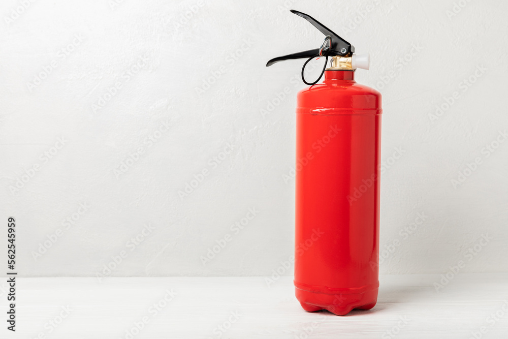 Fire extinguisher on a white texture background. Fire protection, home fire extinguisher. home security concept. Place for text. Copy space. Fire extinguisher on a white texture background. Fire protection, home fire extinguisher. home security concept. Place for text. Copy space.