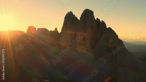 Edges of high peaks at sunrise. Illuminated by the rays of the sun, the craggy peaks of Tre Chime di Lavaredo under a clear sky aerial view in backlight photo