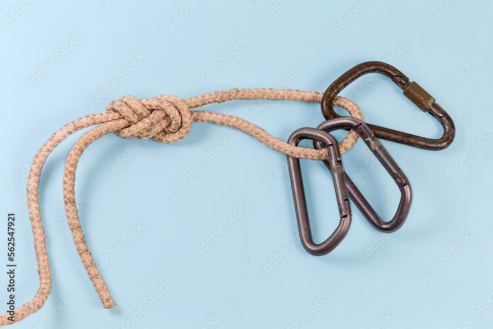 Carabiners in rope knot аigure-eight loop on blue background