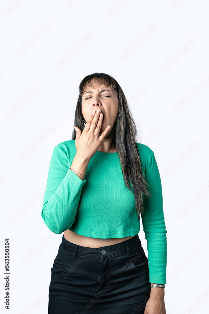 Hispanic brunette woman yawning and covering her mouth with hand on white background. Vertical photography Hispanic brunette woman yawning and covering her mouth with hand on white background. Vertical photography