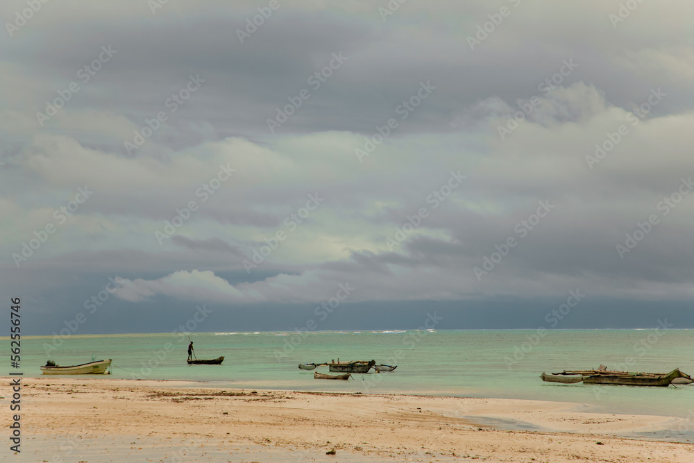 Man on a traditional boat off the coast of Kenya at sunset. Cloudy sky