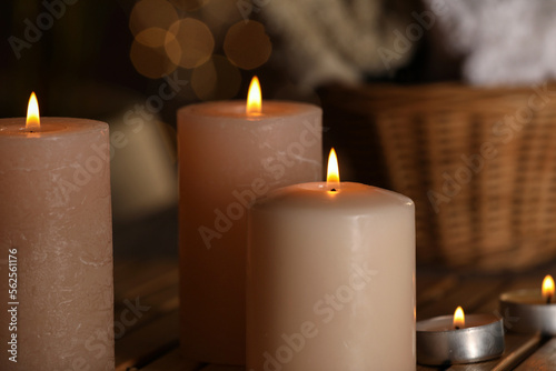 Spa composition with burning candles on wooden table, closeup. Space for text