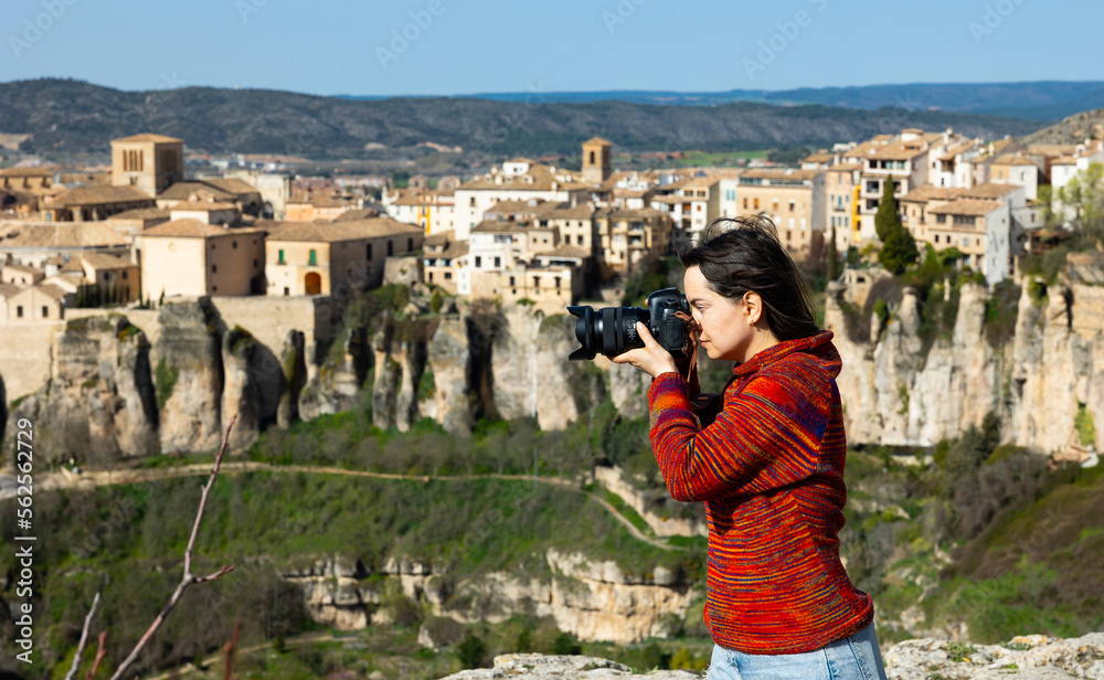 Woman tourist with camera on the background of buildings of the Spanish city of Cuenca