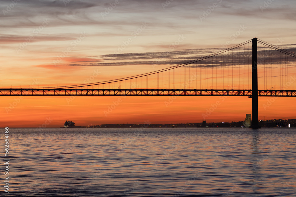 Lisbon and 25th of April Bridge at orange sunset
