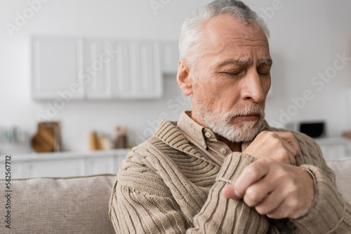 Wallpaper Mural depressed senior man with parkinson disease sitting with closed eyes at home. Torontodigital.ca