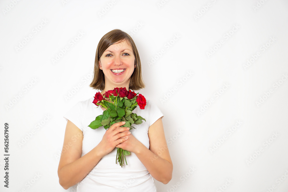 Portrait of happy smiling girl in white shirt with bouquet of red roses in hands. Portrait of happy smiling girl in white shirt with bouquet of red roses in hands.