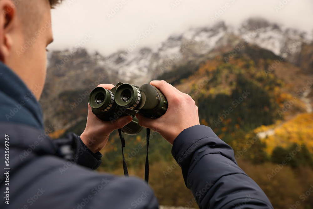 Boy holding binoculars in beautiful mountains, closeup. Space for text Boy holding binoculars in beautiful mountains, closeup. Space for text
