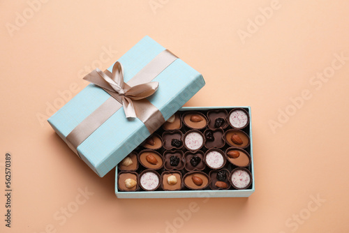 Open box of delicious chocolate candies on beige background, flat lay © New Africa