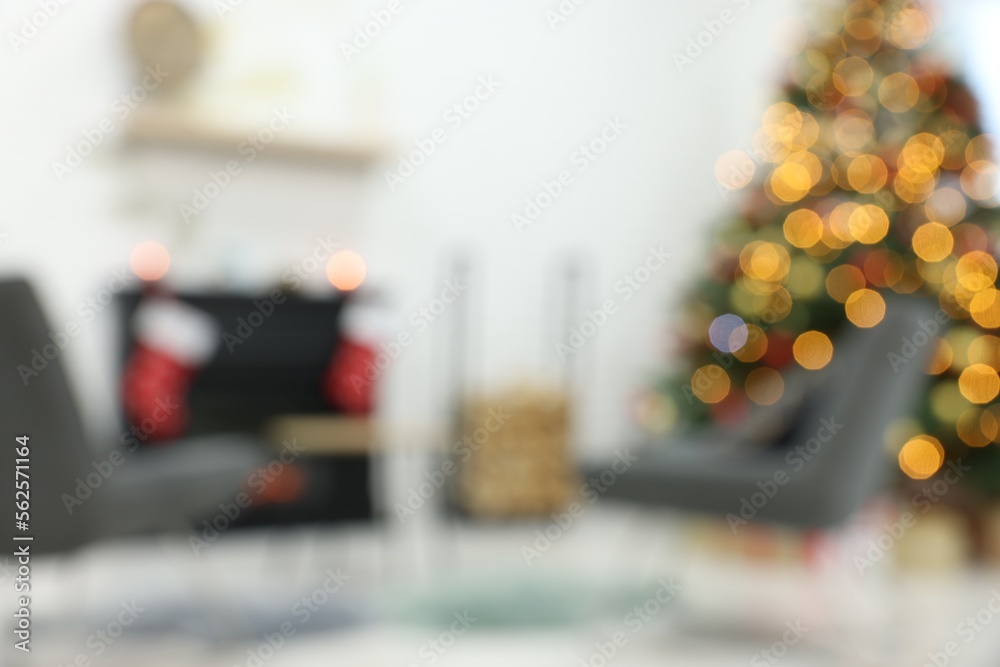 Beautiful Christmas tree near fireplace and cosy armchairs indoors, blurred view Beautiful Christmas tree near fireplace and cosy armchairs indoors, blurred view