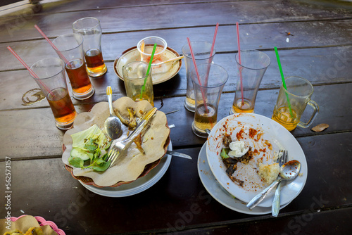 stacks of plates and glasses after eating in the Yogyakarta state university food court. pile of dirty dishes in a restaurantdishes photo