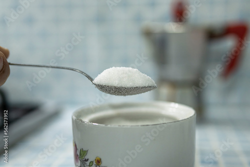 Close up view of a spoon full of rafined white sugar, hyperglycemia health care concept photo