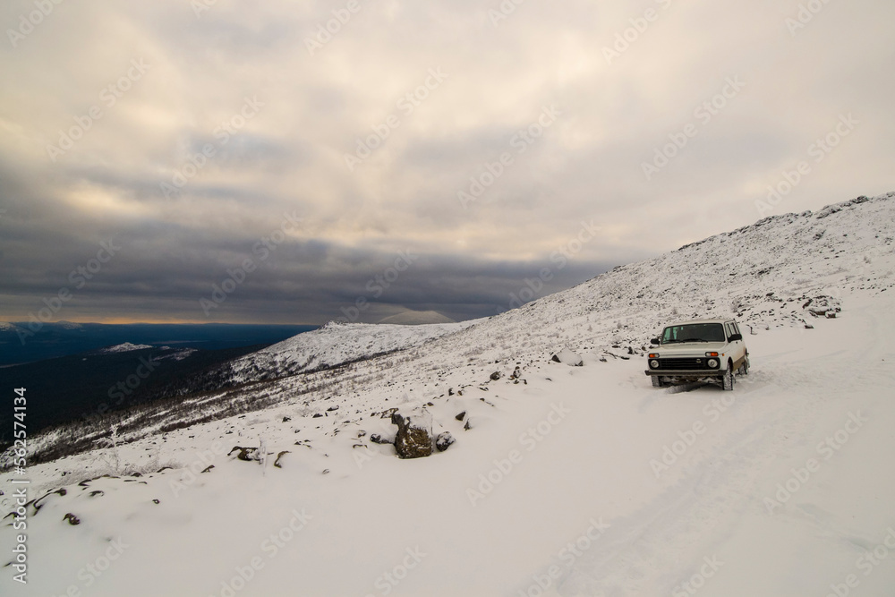 Off-road vehicle parked on field against cloudy sky Off-road vehicle parked on field against cloudy sky