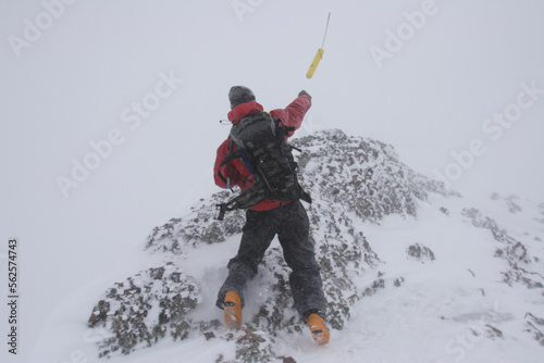A ski patroller throws a stick of dynamite while on his snow safety route. Ski patrollers throw dynamite to trigger potential av photo