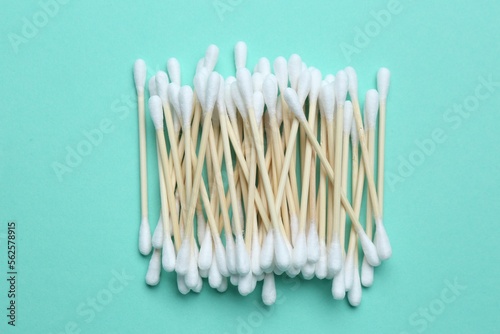 Heap of cotton buds on turquoise background  top view